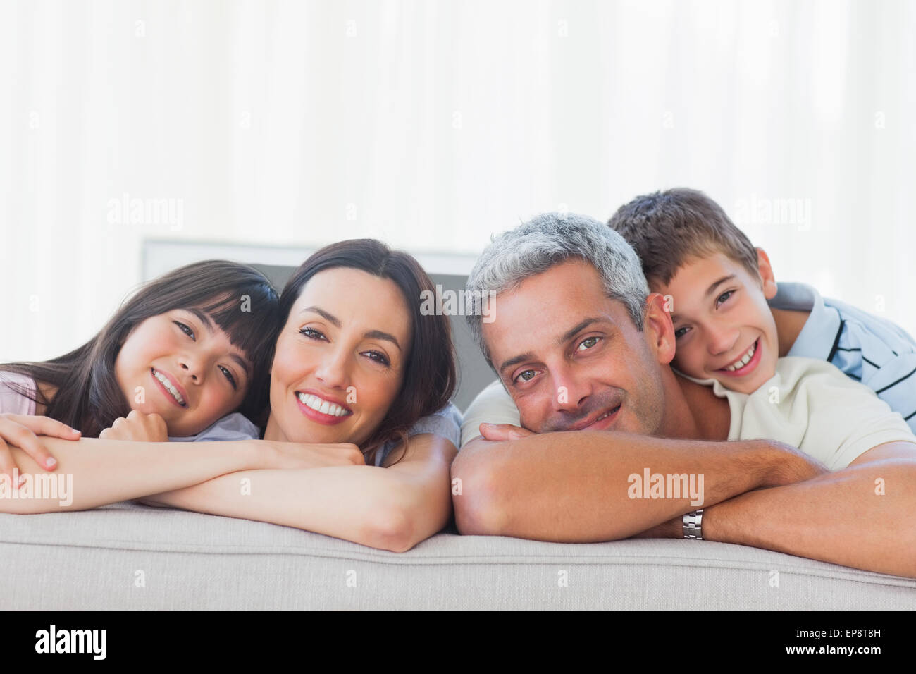Beautiful family in sitting room smiling at camera Stock Photo - Alamy