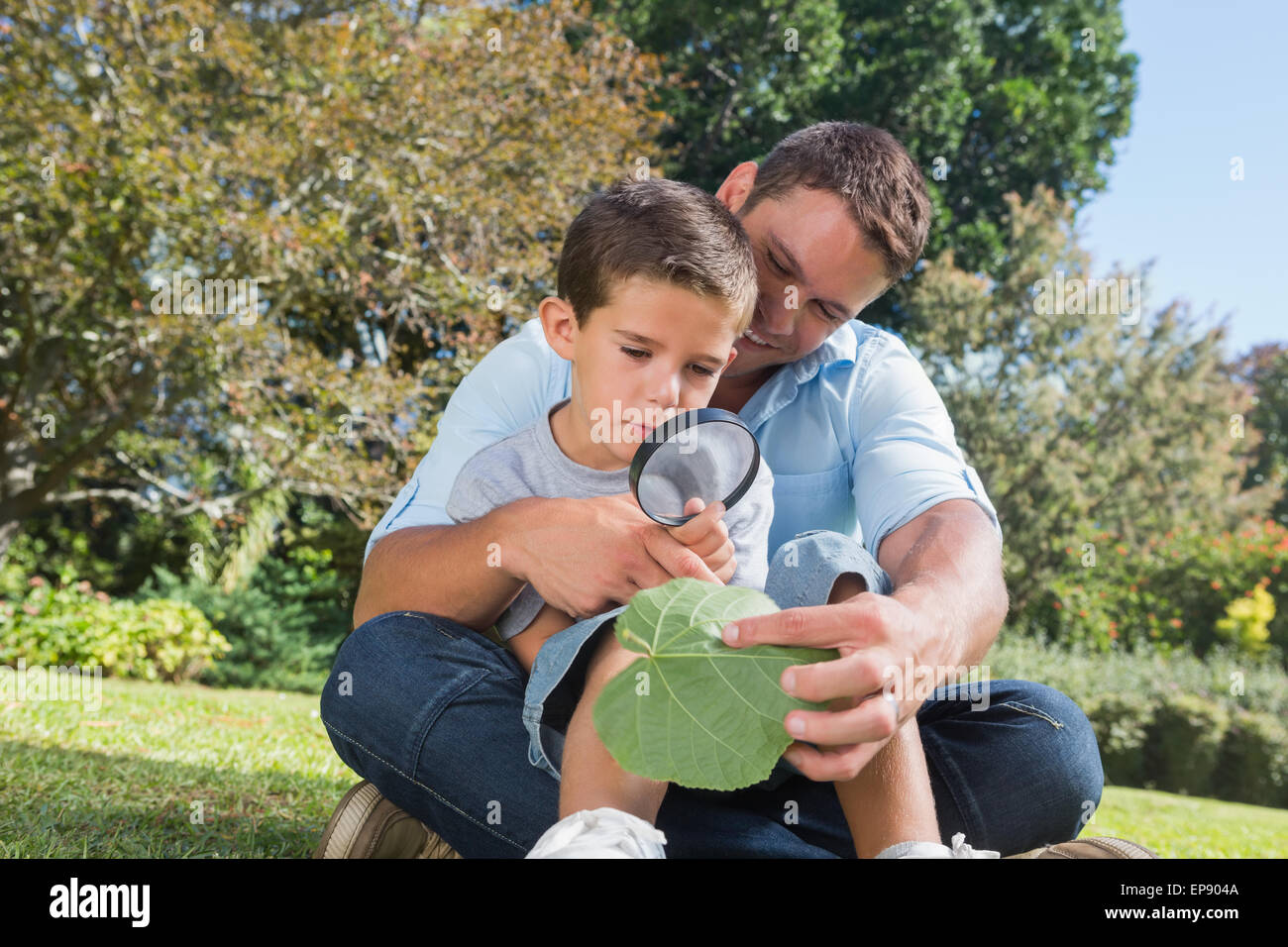 Родители и дети. Дети рассматривают книжку из рекламы. Воспитание ребенка. Папа и лупа. Ребенок с мамой рассматривают книжку на полу.
