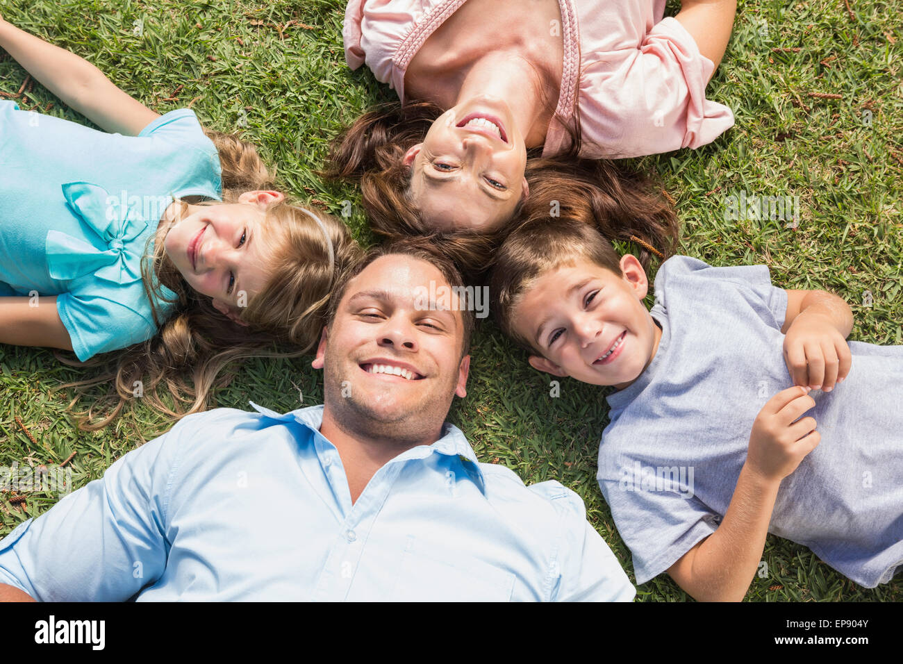 Happy family lying on the grass in a circle Stock Photo - Alamy