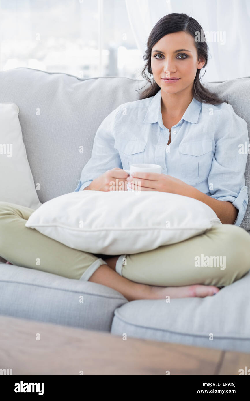Pretty woman lying on sofa holding cup of tea Stock Photo - Alamy
