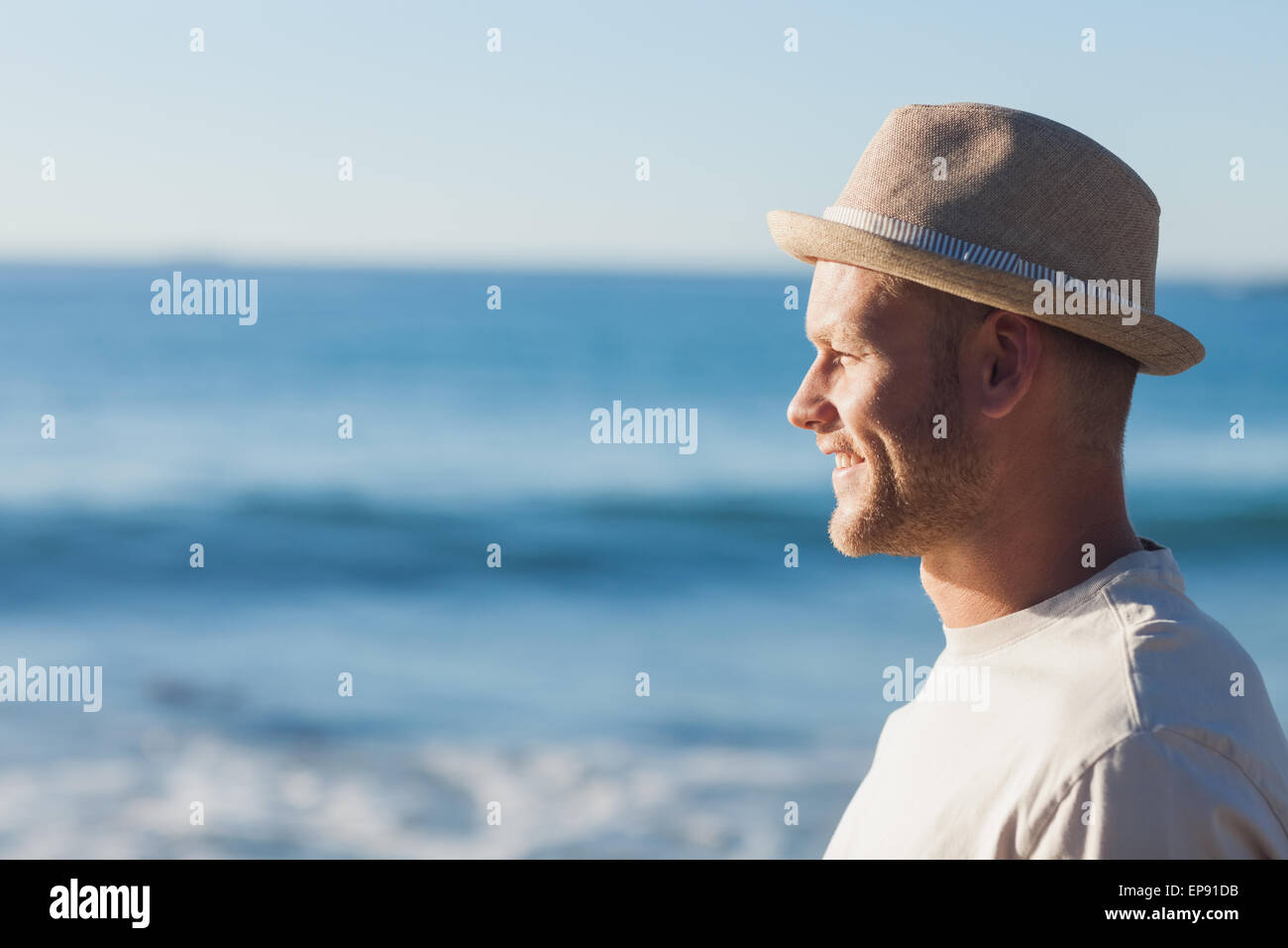 Handsome man wearing straw hat looking at the sea Stock Photo Alamy