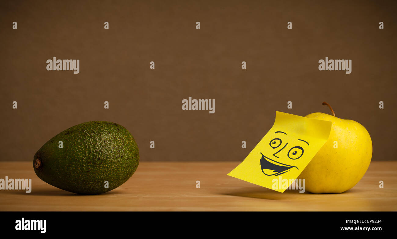 Apple with post-it note smiling at avocado Stock Photo - Alamy