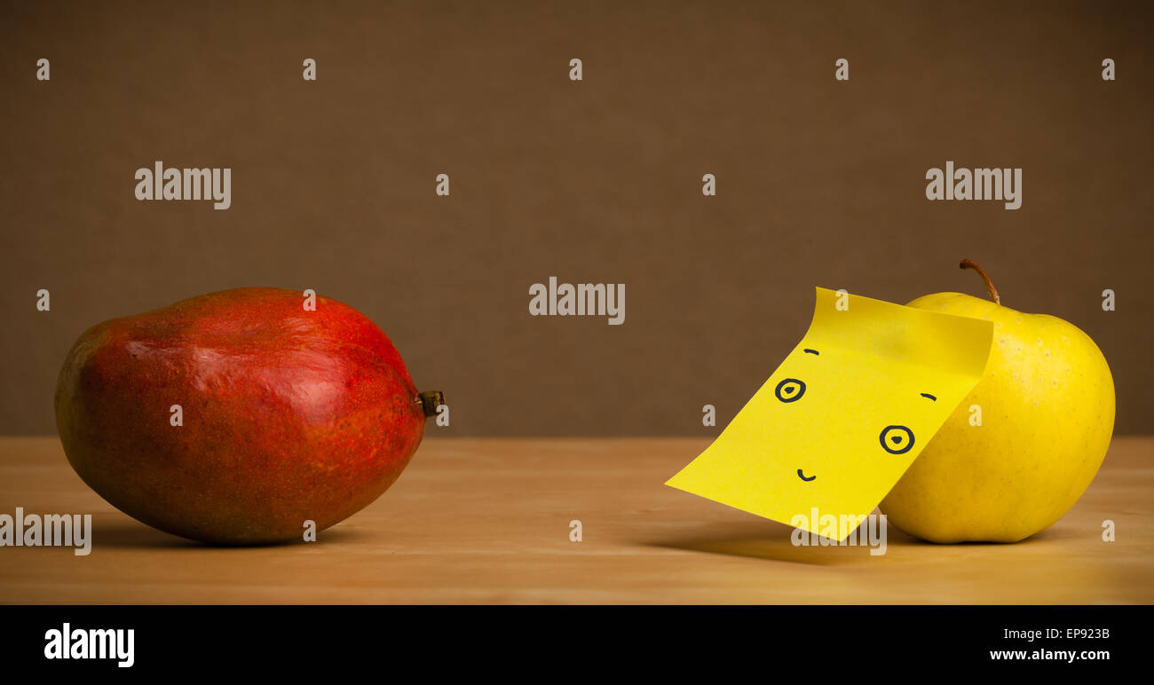 Apple with postit note looking at mango Stock Photo Alamy
