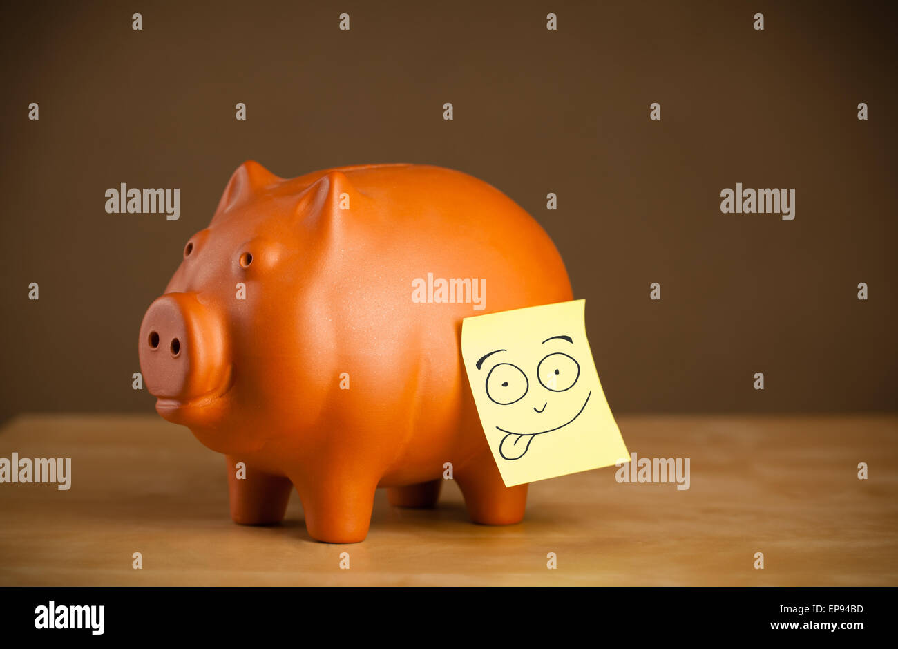 Postit note with smiley face sticked on a piggy bank Stock Photo Alamy