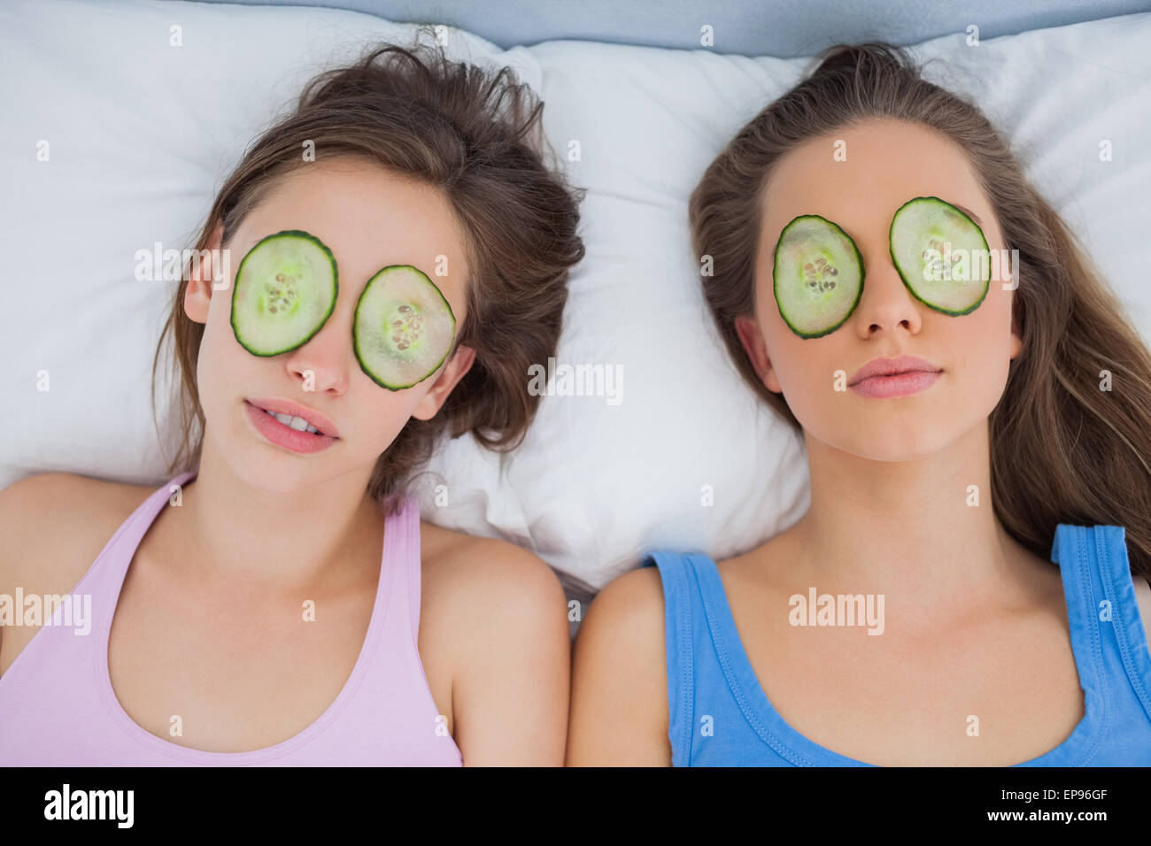 Friends lying in bed with cucumber slices on eyes Stock Photo Alamy