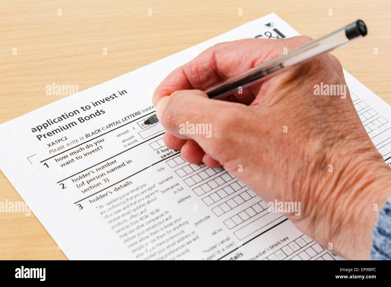 Wealthy Elderly Senior Pensioner Completing An Application Form To Buy Investments In Premium Bonds England Uk Britain Stock Photo Alamy