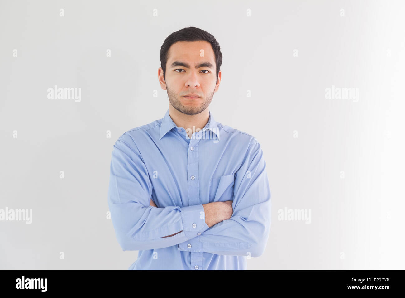 Serious man standing with arms crossed and looking at camera Stock ...