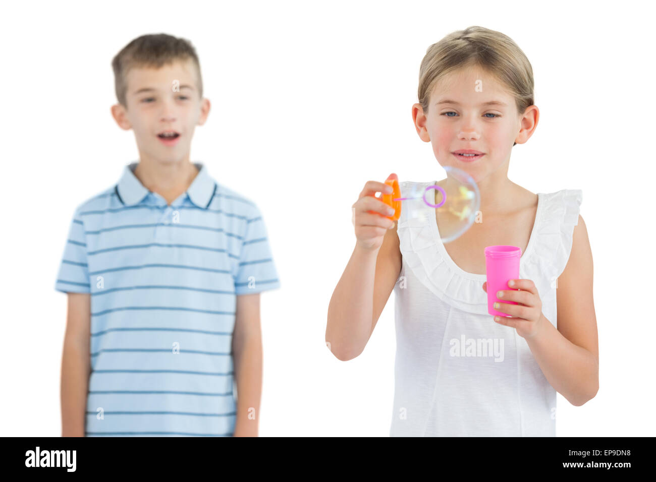 Girl making bubbles while her brother looking at her Stock Photo