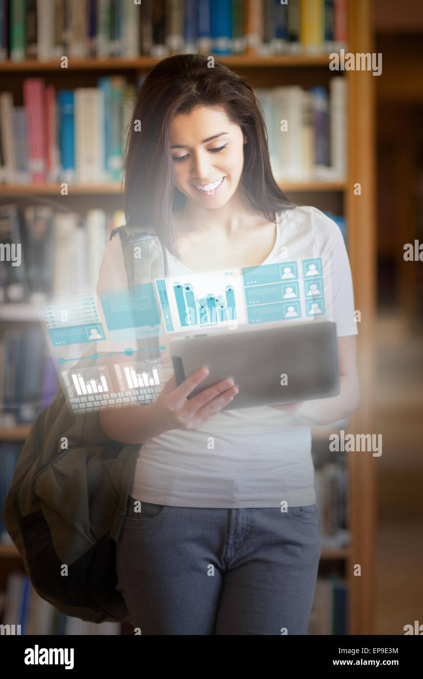 Smiling pretty student working on her futuristic tablet Stock Photo