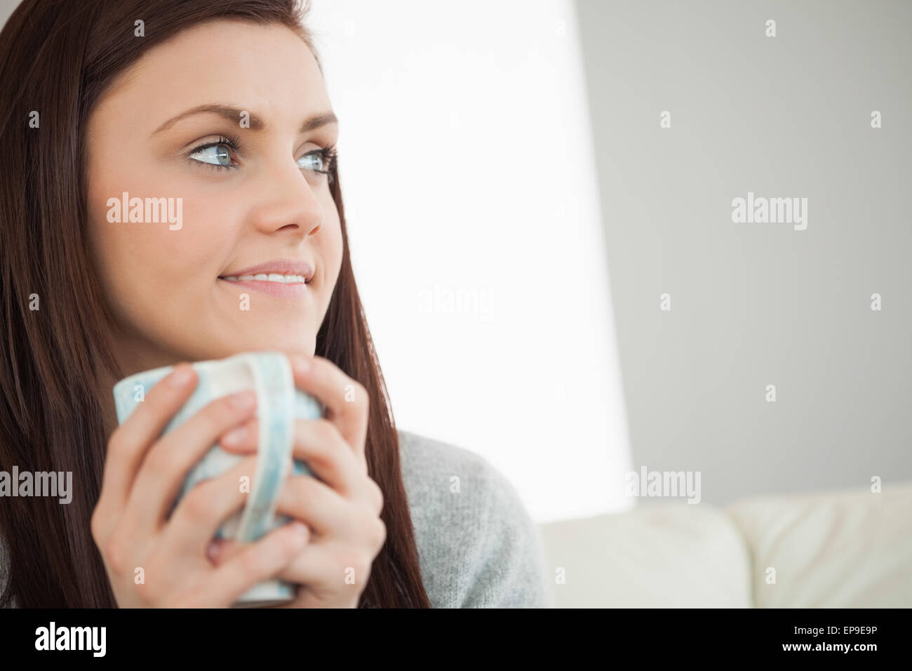 Thoughtful girl holding a cup of coffee and looking away Stock Photo ...
