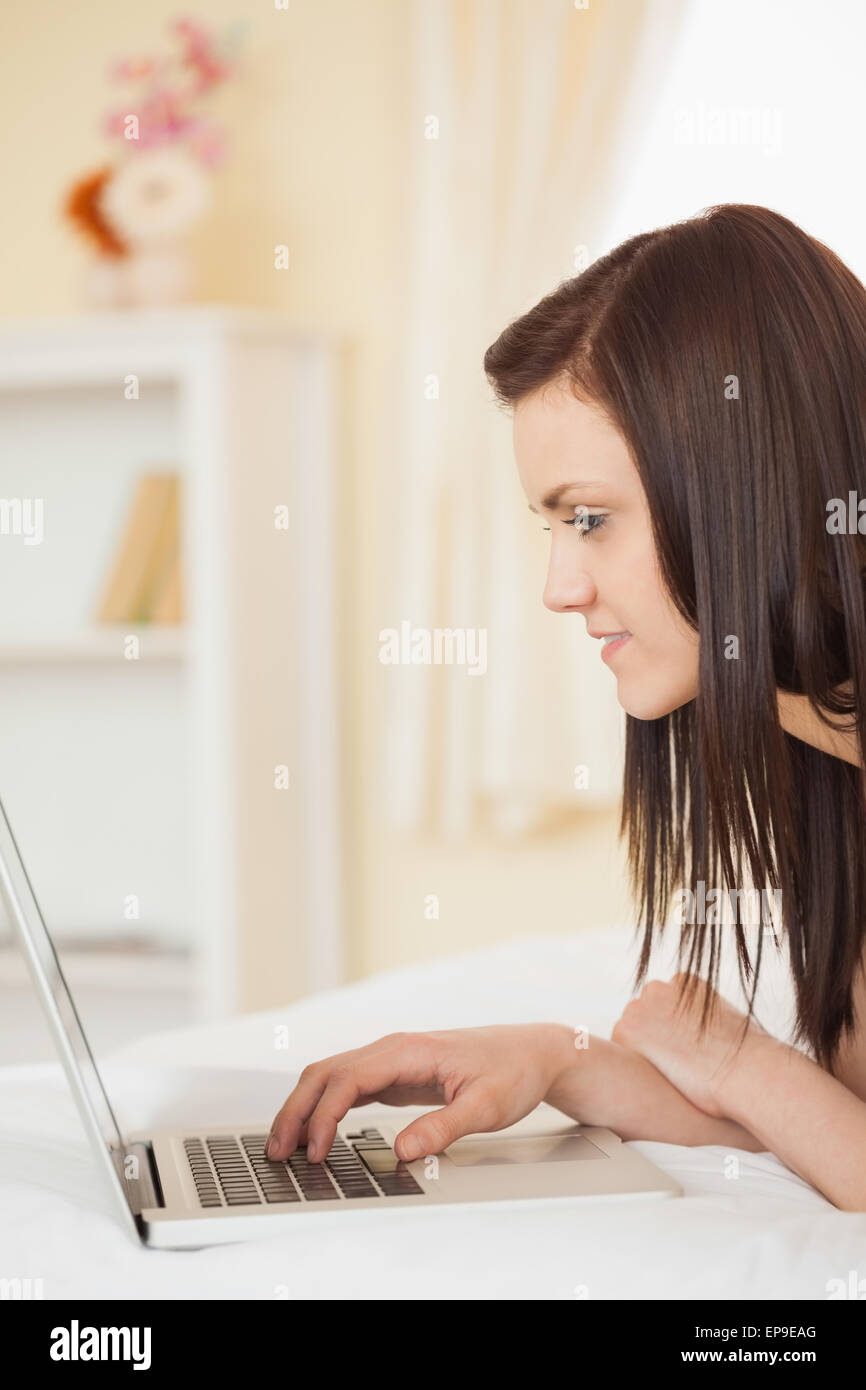 Pretty young girl using a laptop lying on her bed Stock Photo - Alamy