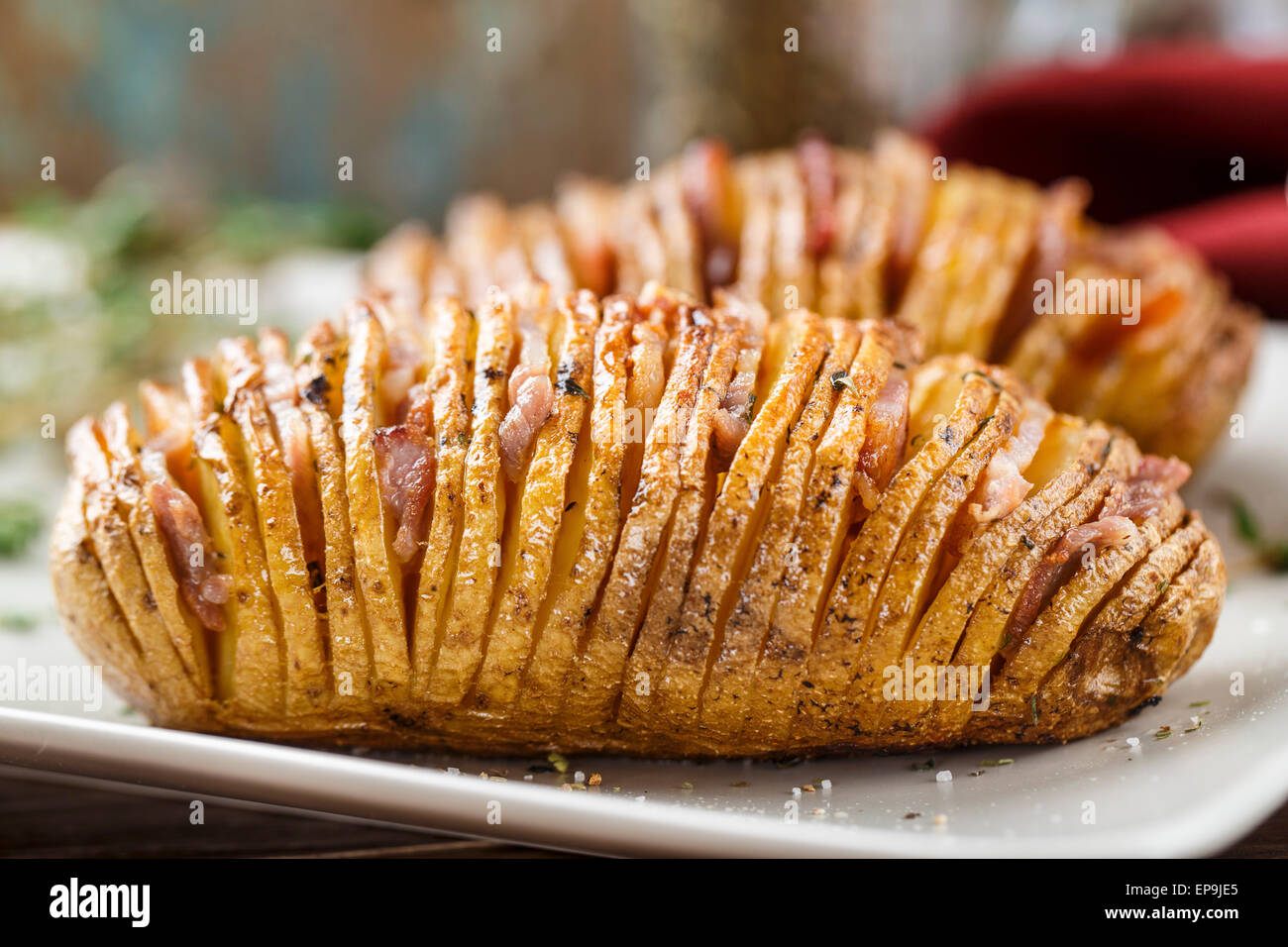 Hasselback potatoes with herbs on a plate Stock Photo Alamy