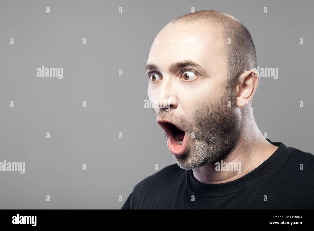 amazed man portrait isolated on gray background Stock Photo - Alamy