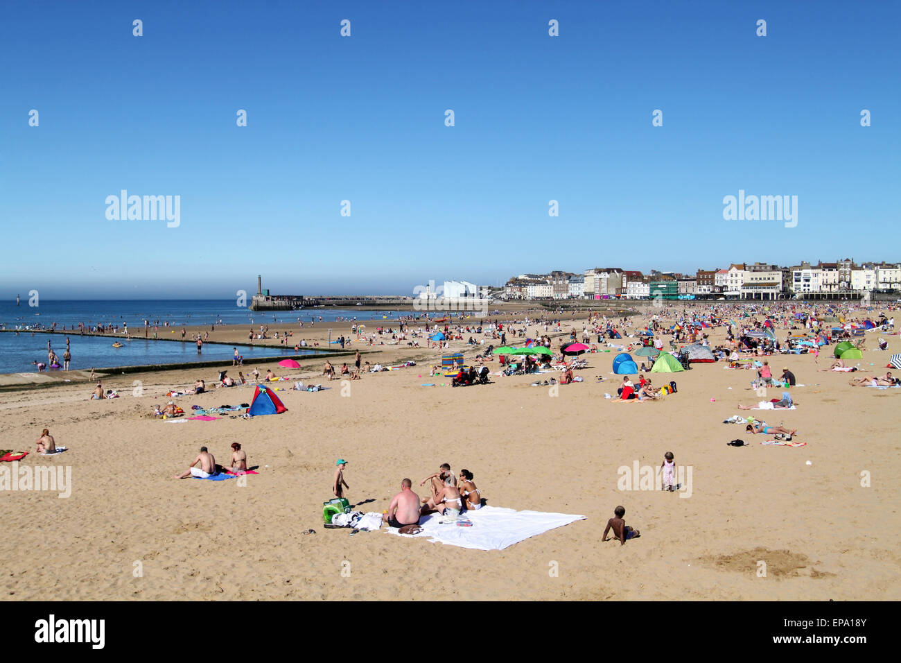 People sunbathing at Margate beach in Kent with the Turner Contemporary Art Gallery in the distance Stock Photo