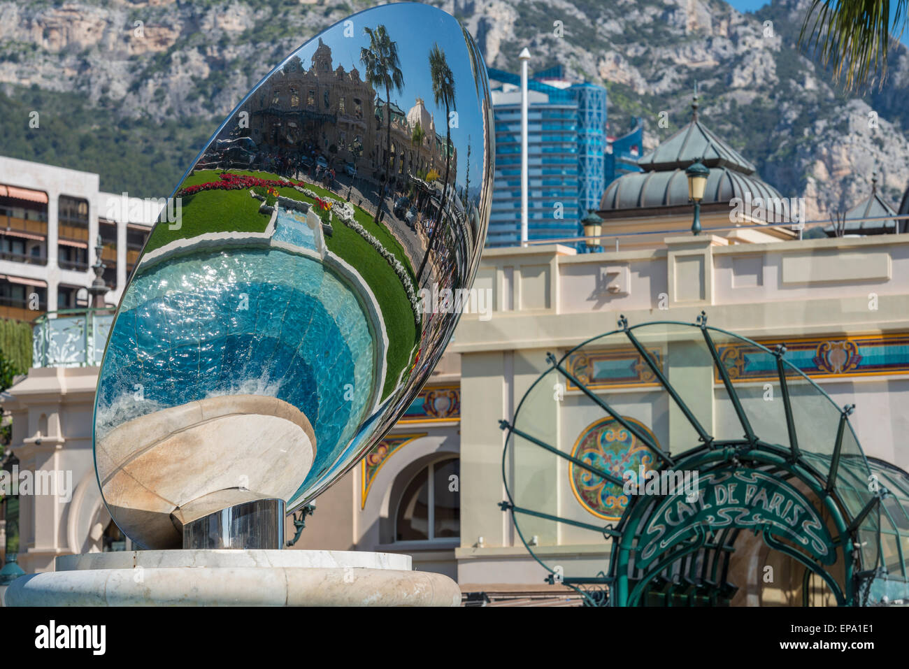 A reflection of the casino in a metal sculpture and the Cafe de Paris entrance in the background in Monte Carlo, Monaco Stock Photo
