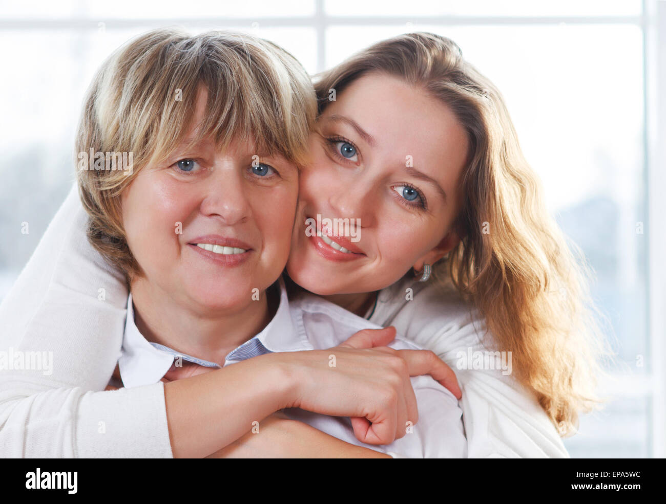 Close up portrait of a mature mother and adult daughter being close and hugging Stock Photo