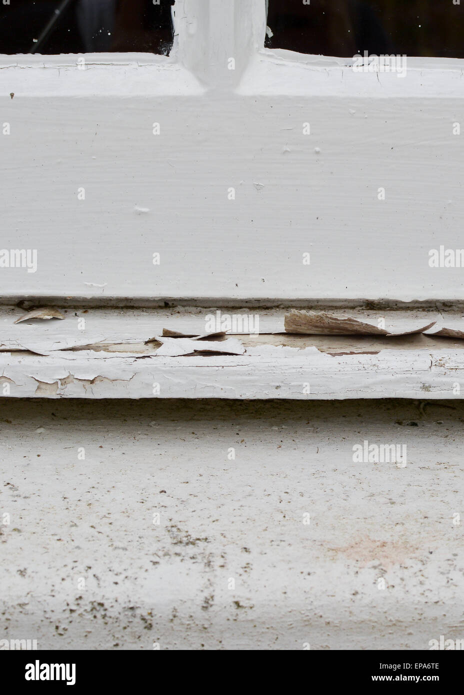 white exterior paint peeling away from wooden window sill Stock Photo