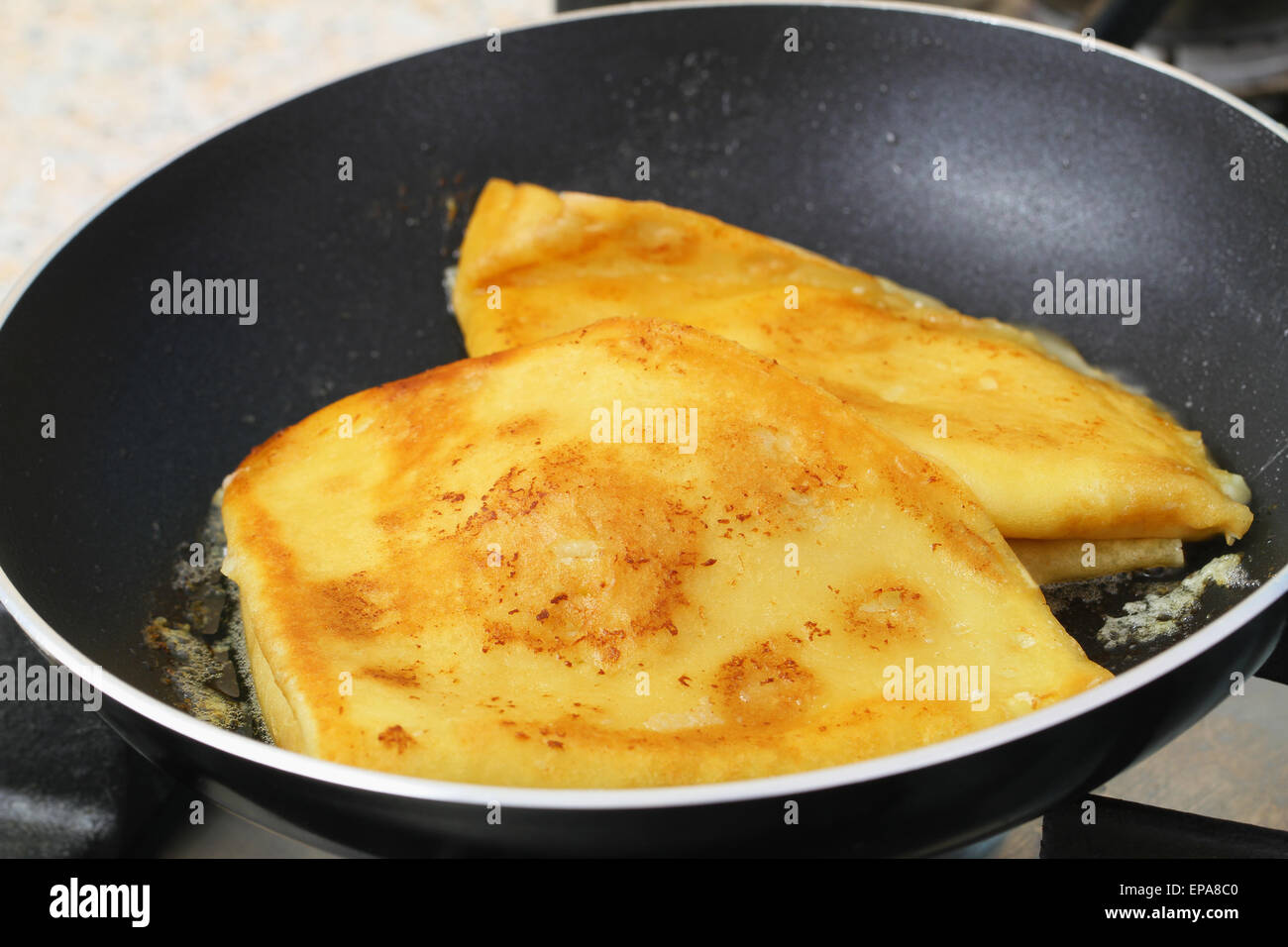 Pancakes fried in butter in frying pan Stock Photo