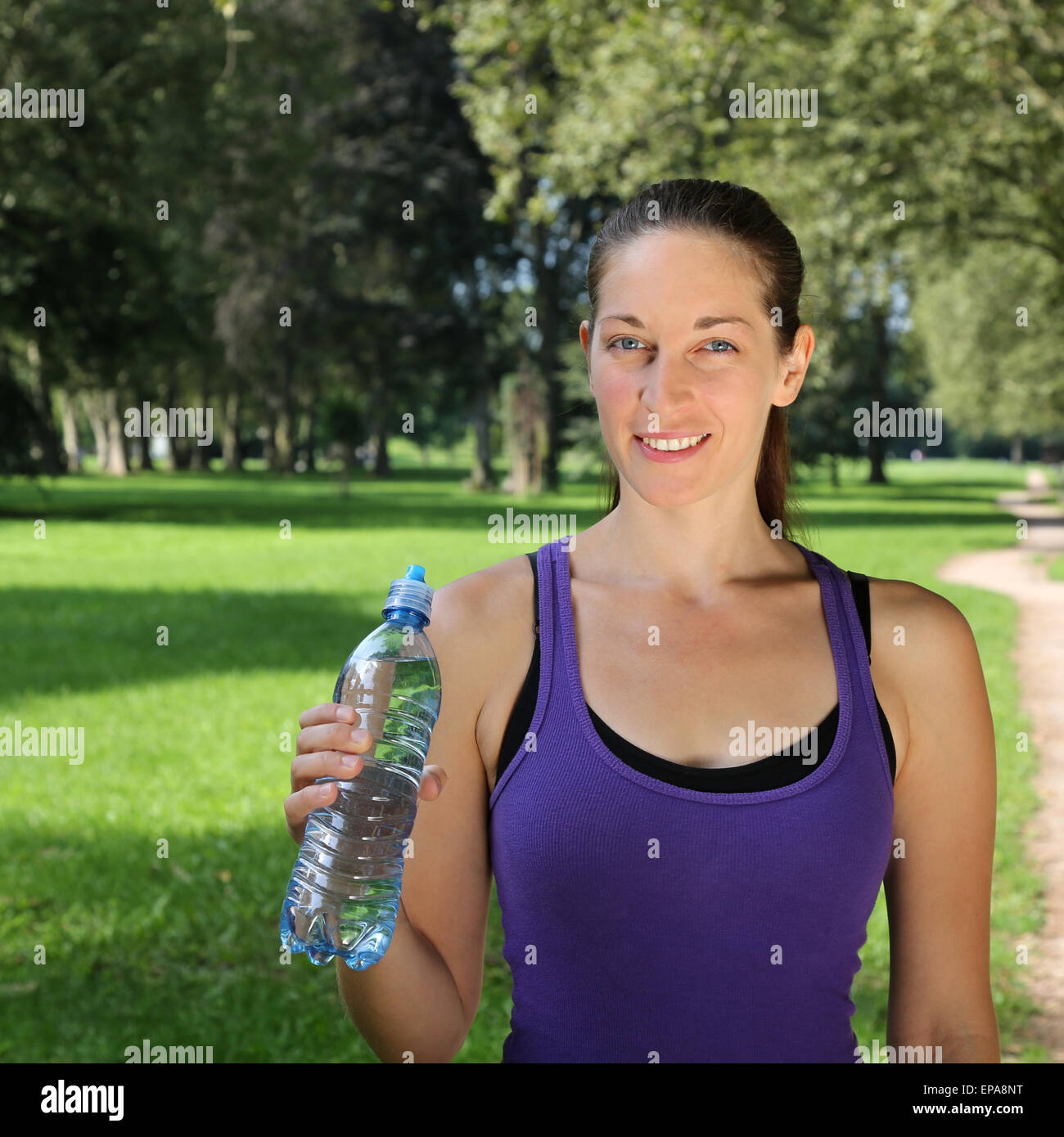 Sportliche Frau mit Wasserflasche beim Joggen oder Laufen Stock Photo