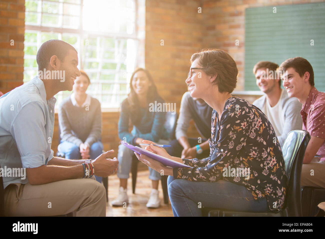 group watching man woman talking group therapy Stock Photo