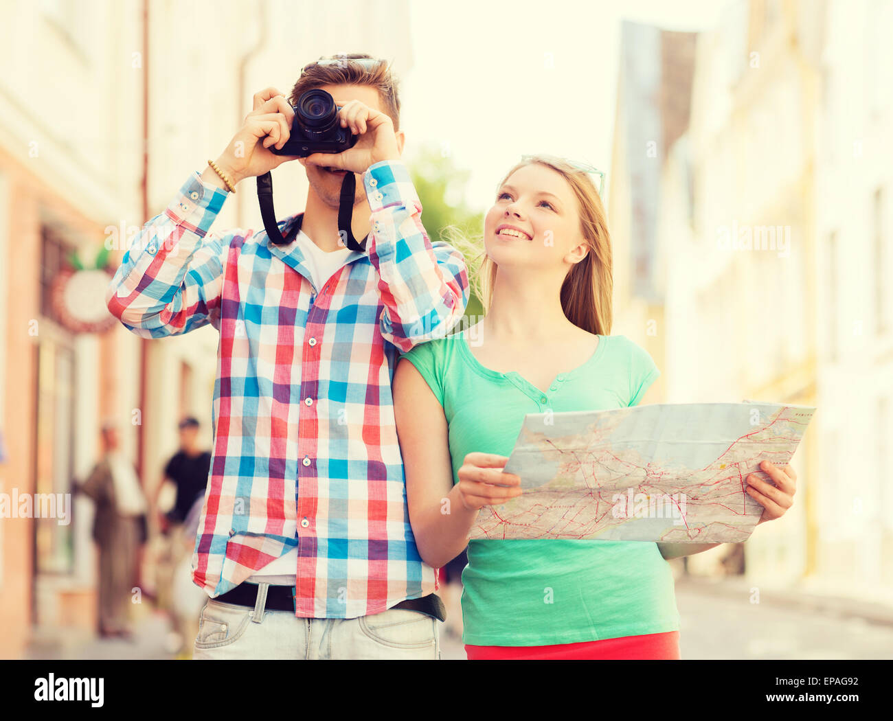 smiling couple with map and photo camera in city Stock Photo
