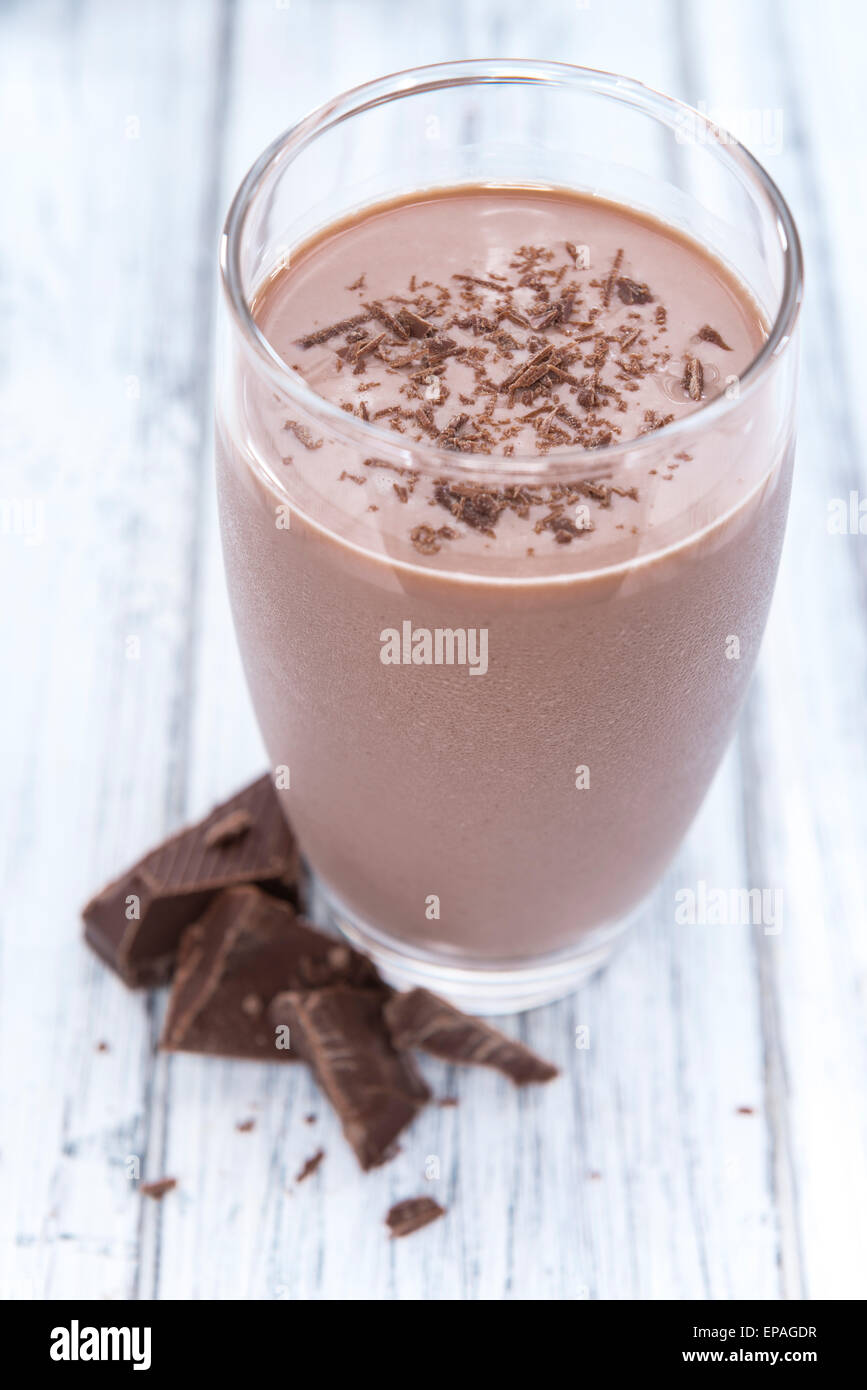 Cold Chocolate Milk drink (close-up shot) on wooden background Stock Photo