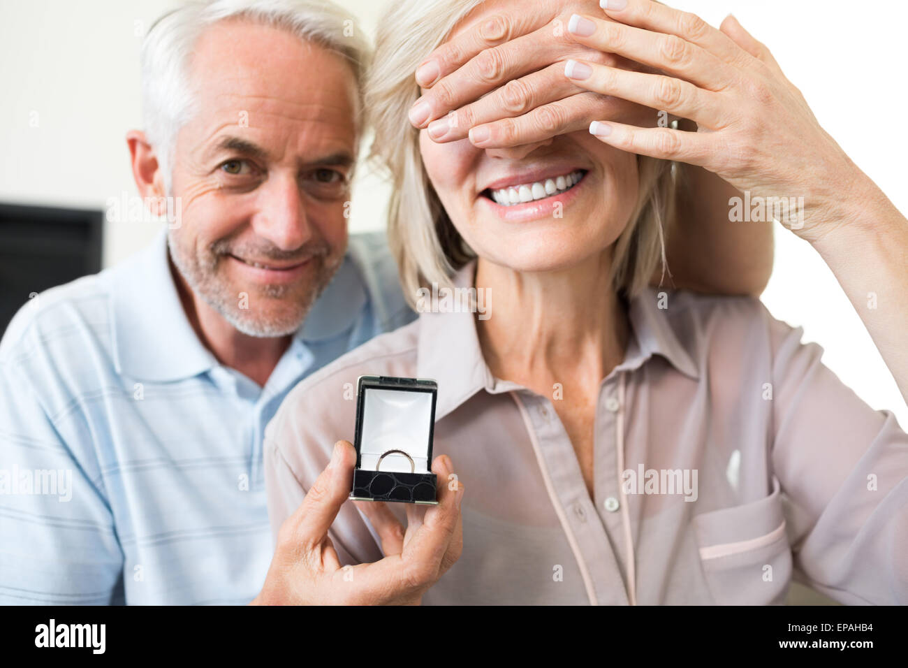 Smiling man surprising woman with a wedding ring Stock Photo - Alamy