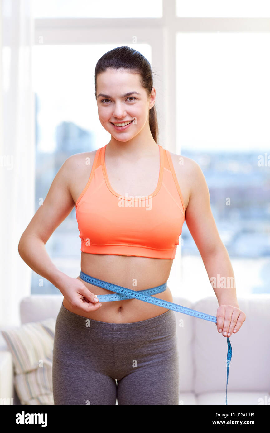 Girl Measures Her Waist Looking Down. Attractive Young Woman In Sports Bra  With Tape Measure On Background Of Sky Stock Photo, Picture and Royalty  Free Image. Image 38922572.