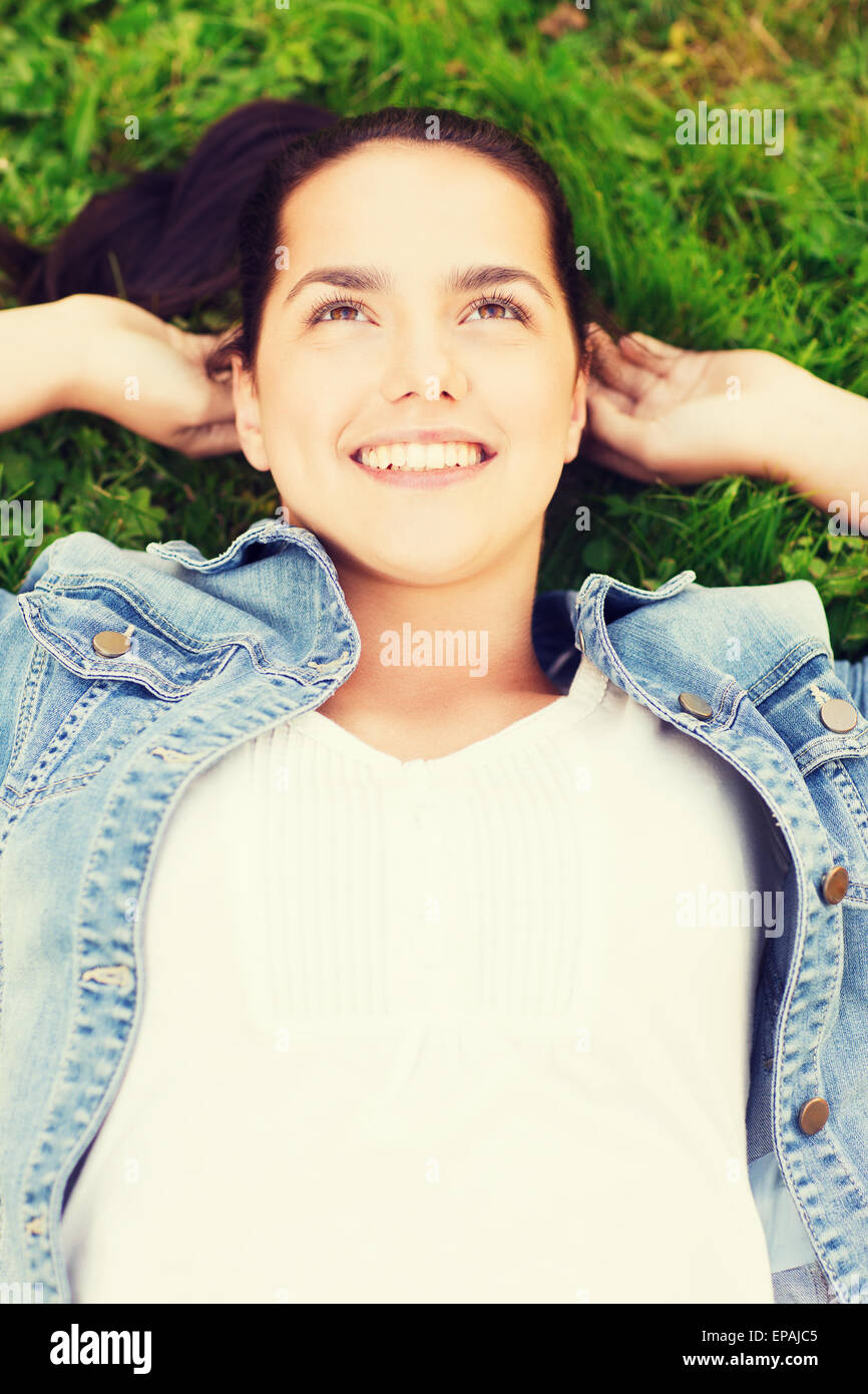 smiling young girl lying on grass Stock Photo - Alamy