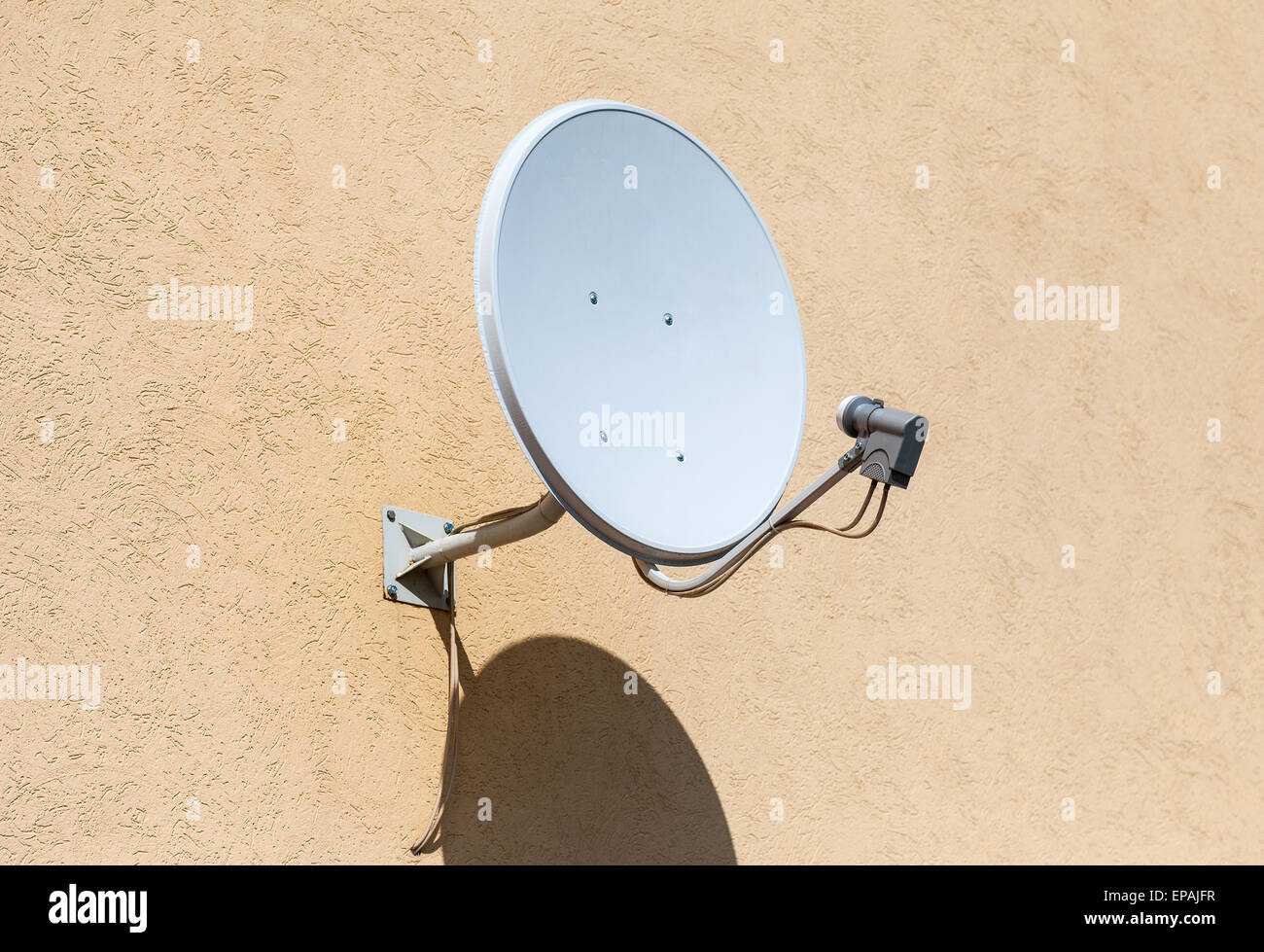 Satellite dish mounted on the wall of house Stock Photo