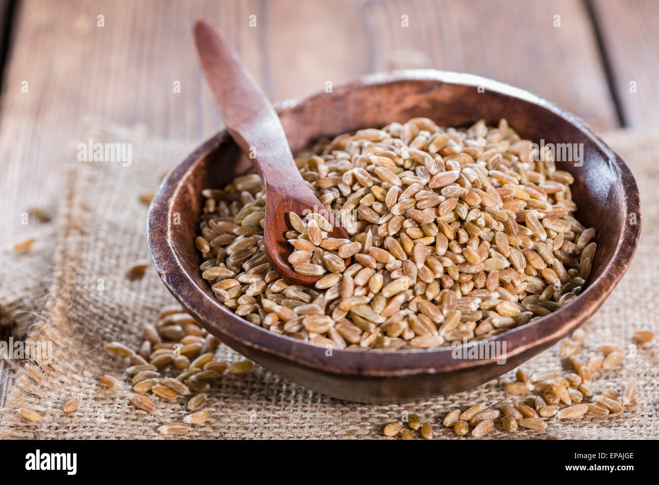 Bowl with Spelt (close-up shot) on wooden background Stock Photo