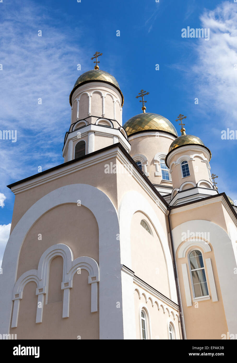 Golden domes of Russian orthodox church with cross against blue sky ...