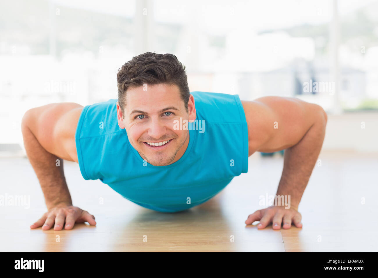 Portrait of a smiling young man doing push ups Stock Photo - Alamy