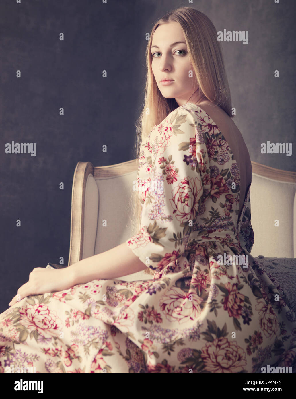 Beautiful blond girl in long dress in living room Stock Photo - Alamy