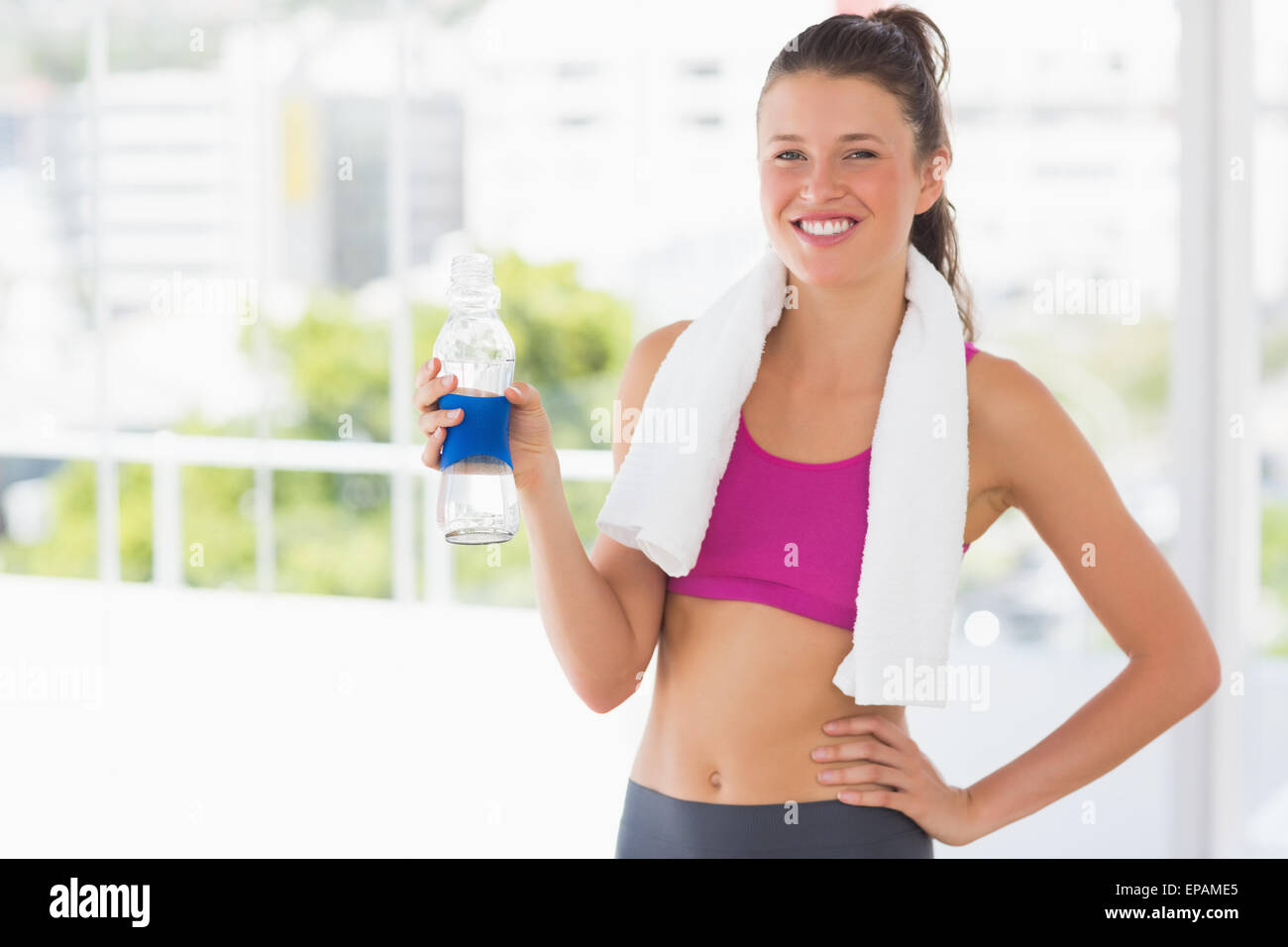 Fit woman with towel and water bottle in gym Stock Photo - Alamy