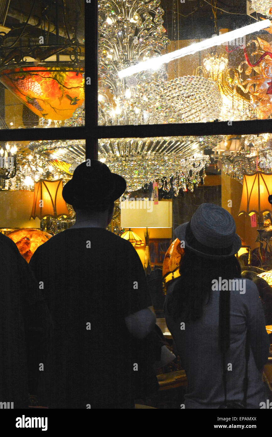 Window shoppers enjoy the night view of a chandelier lighting store