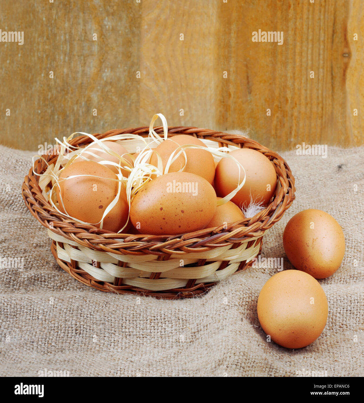 Fresh chicken eggs in straw nest on wooden wall background Stock Photo ...