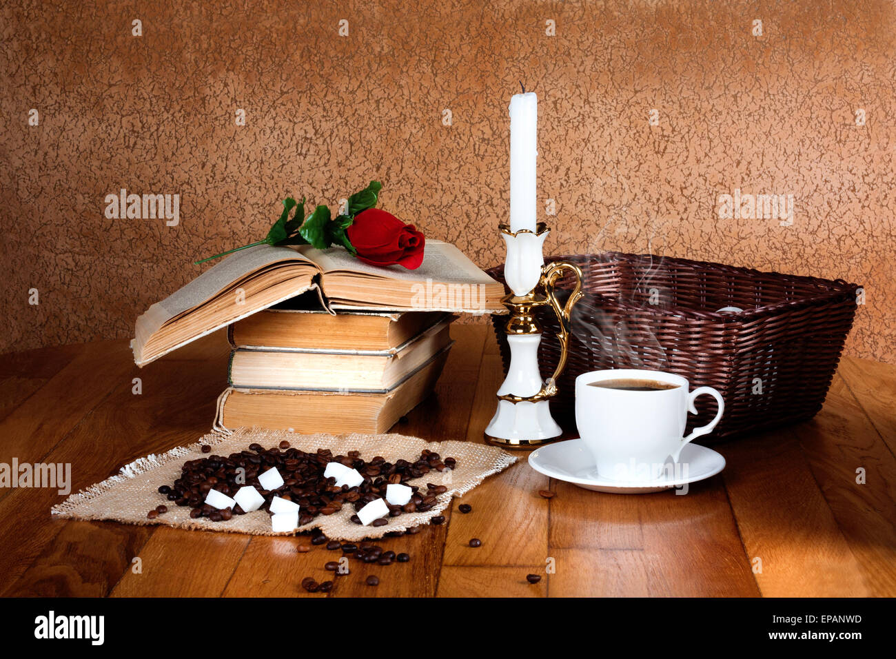 Hot cup of fresh coffee on the wooden table and stack of books to read with red rose Stock Photo