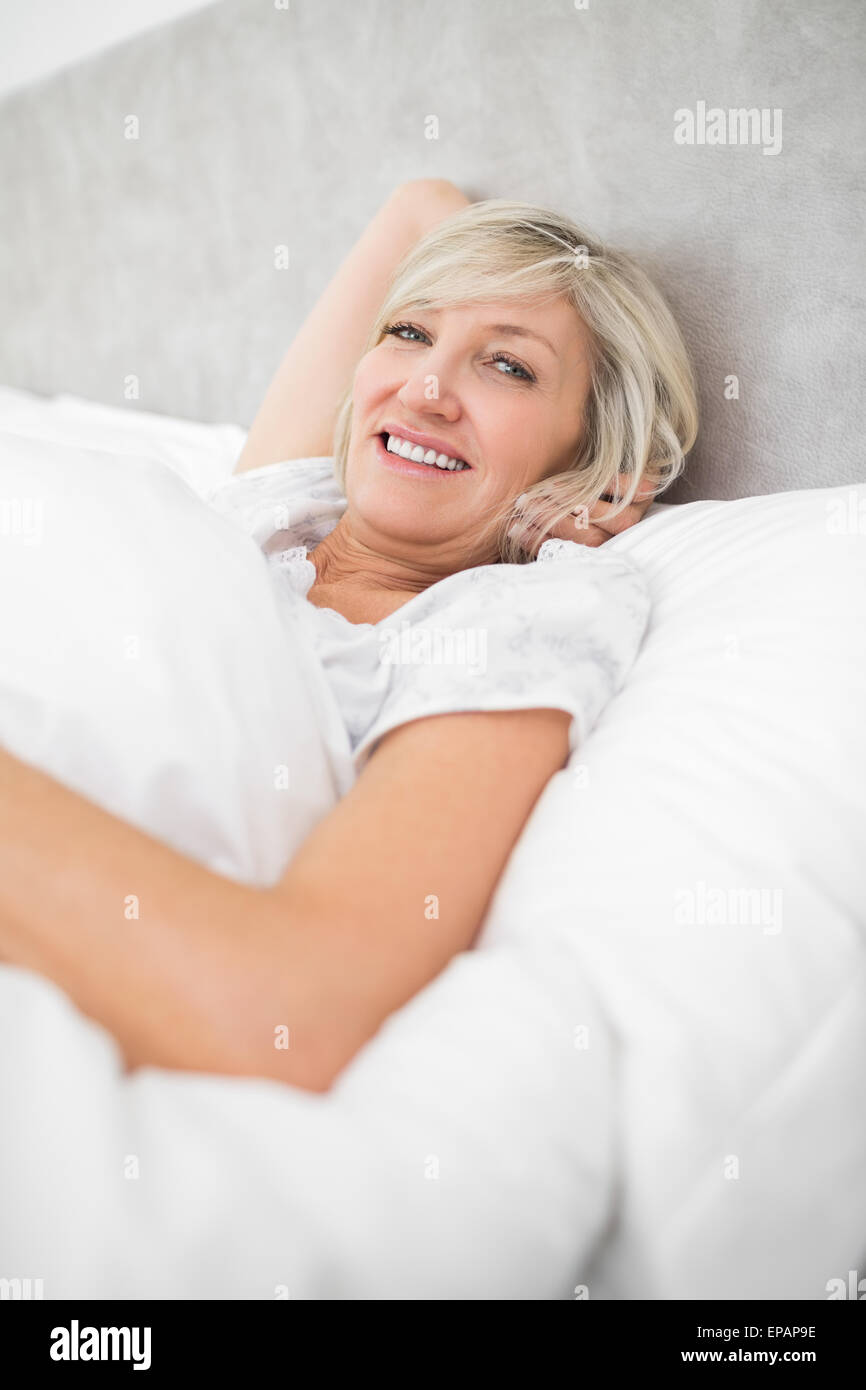 Pretty mature woman resting in bed Stock Photo