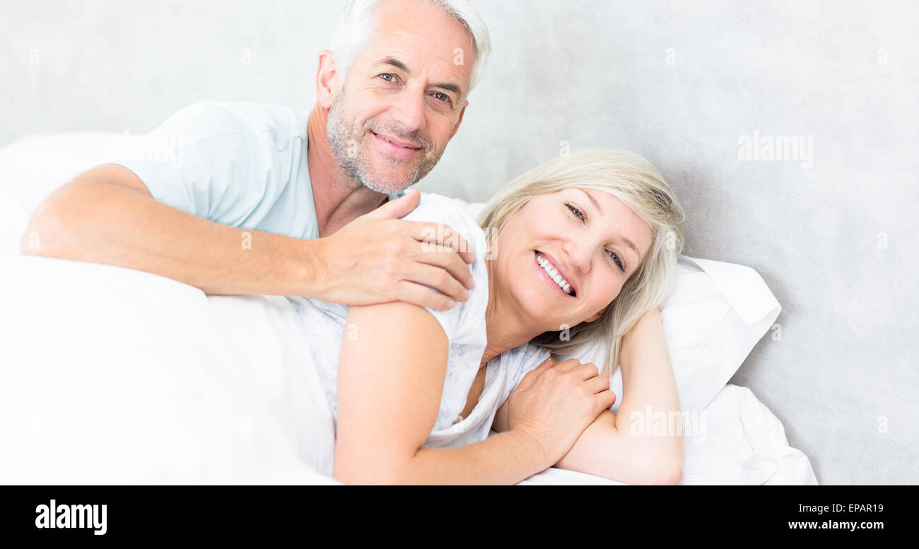 Portrait of a smiling mature couple lying in bed Stock Photo - Alamy
