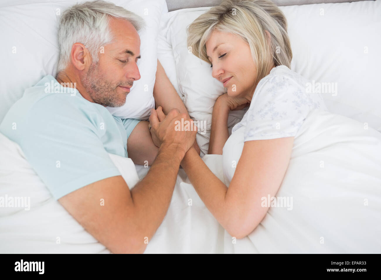 Mature couple lying in bed at home Stock Photo - Alamy