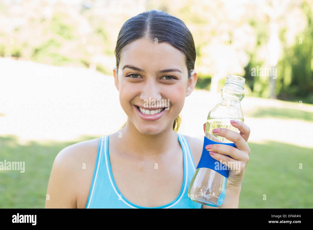Happy sporty woman holding water bottle Stock Photo - Alamy
