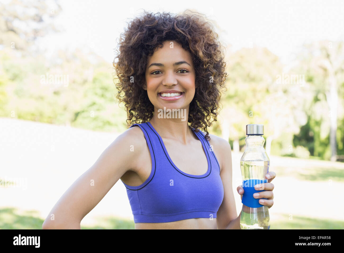 Happy fit woman holding water bottle Stock Photo - Alamy