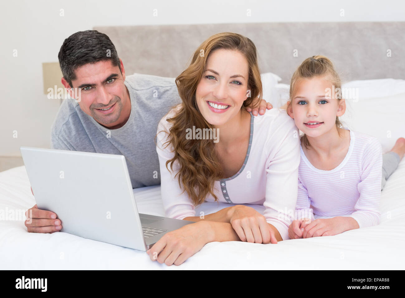 Family with laptop in bed Stock Photo