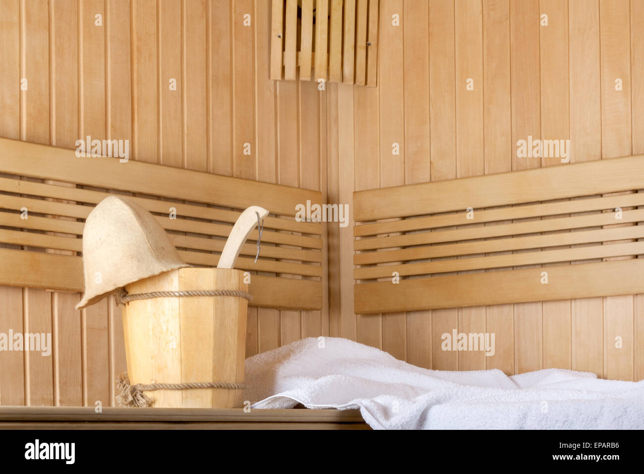 Traditional wooden sauna for relaxation with bucket of water and set of clean towels Stock Photo
