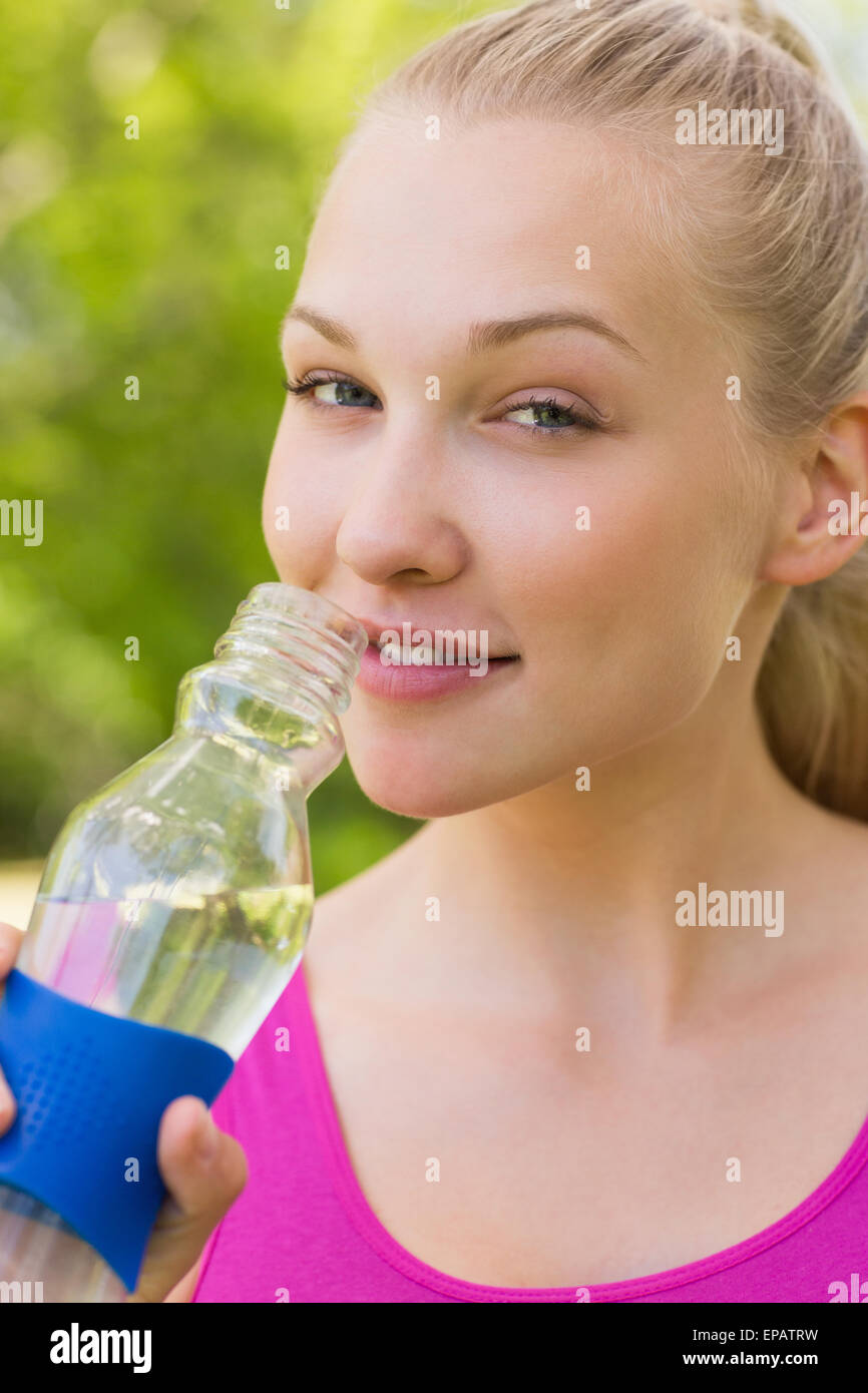 Close-up of a fit woman holding water bottle in park Stock Photo