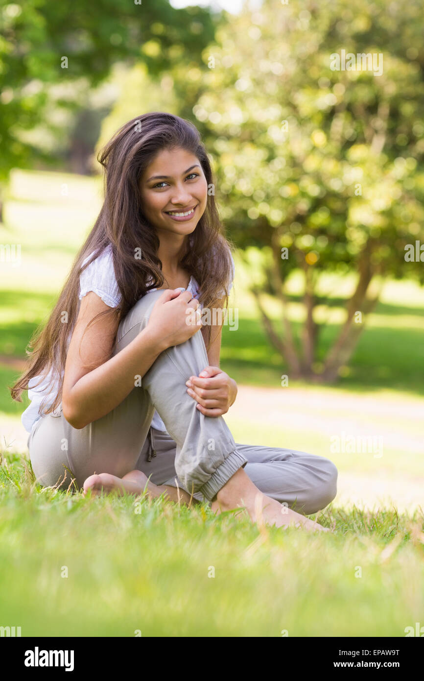Portrait of a smiling woman sitting on grass in park Stock Photo - Alamy