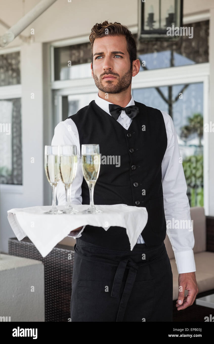 Handsome waiter holding tray of champagne Stock Photo Alamy