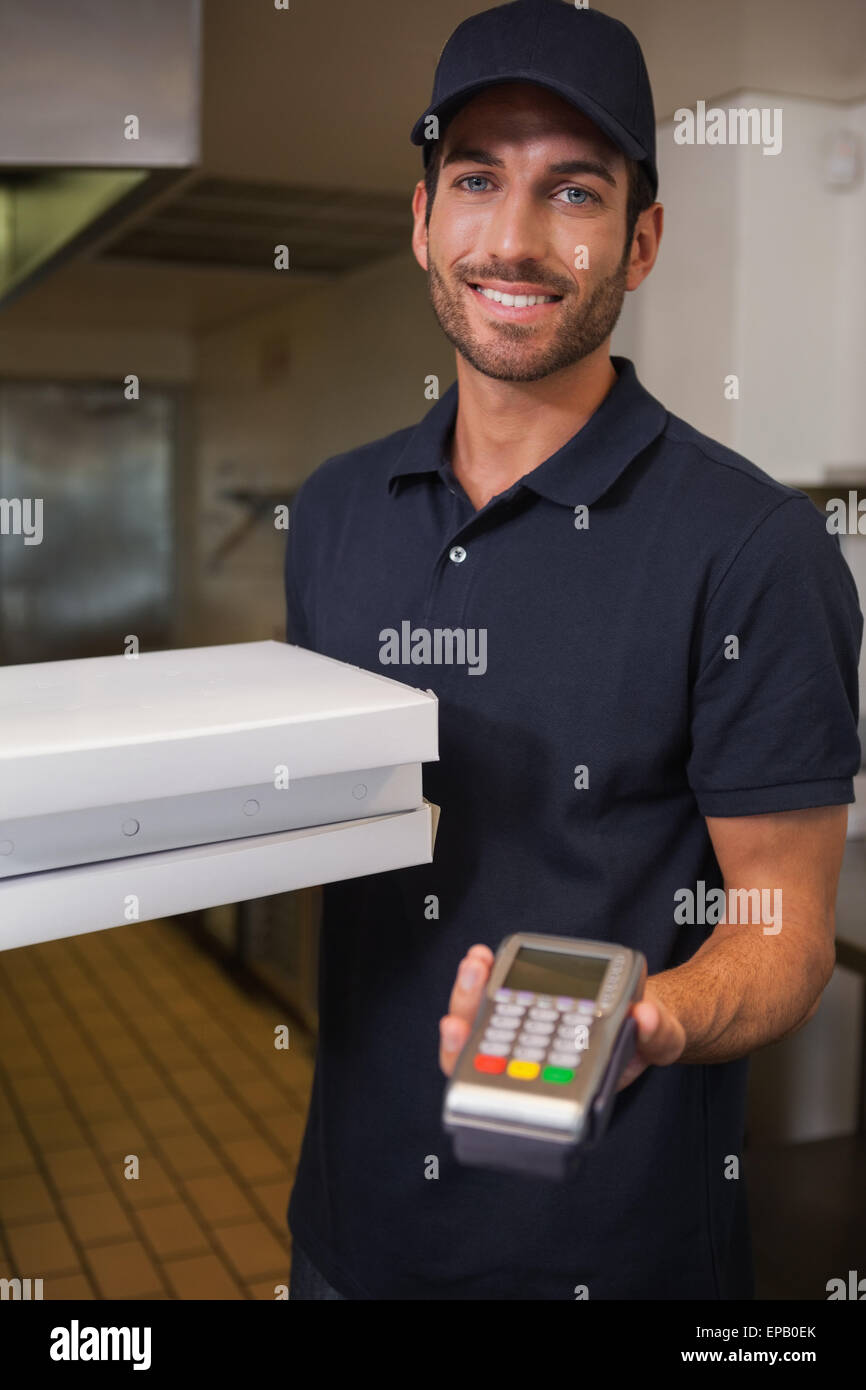 Happy pizza delivery man showing credit card machine Stock Photo Alamy