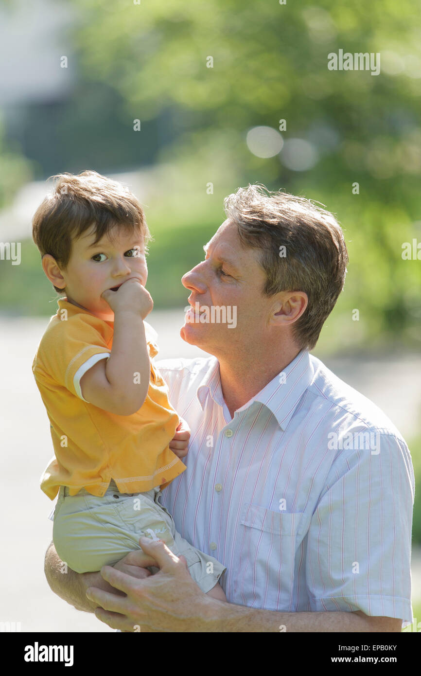 Caring Father holding son on his arm Stock Photo